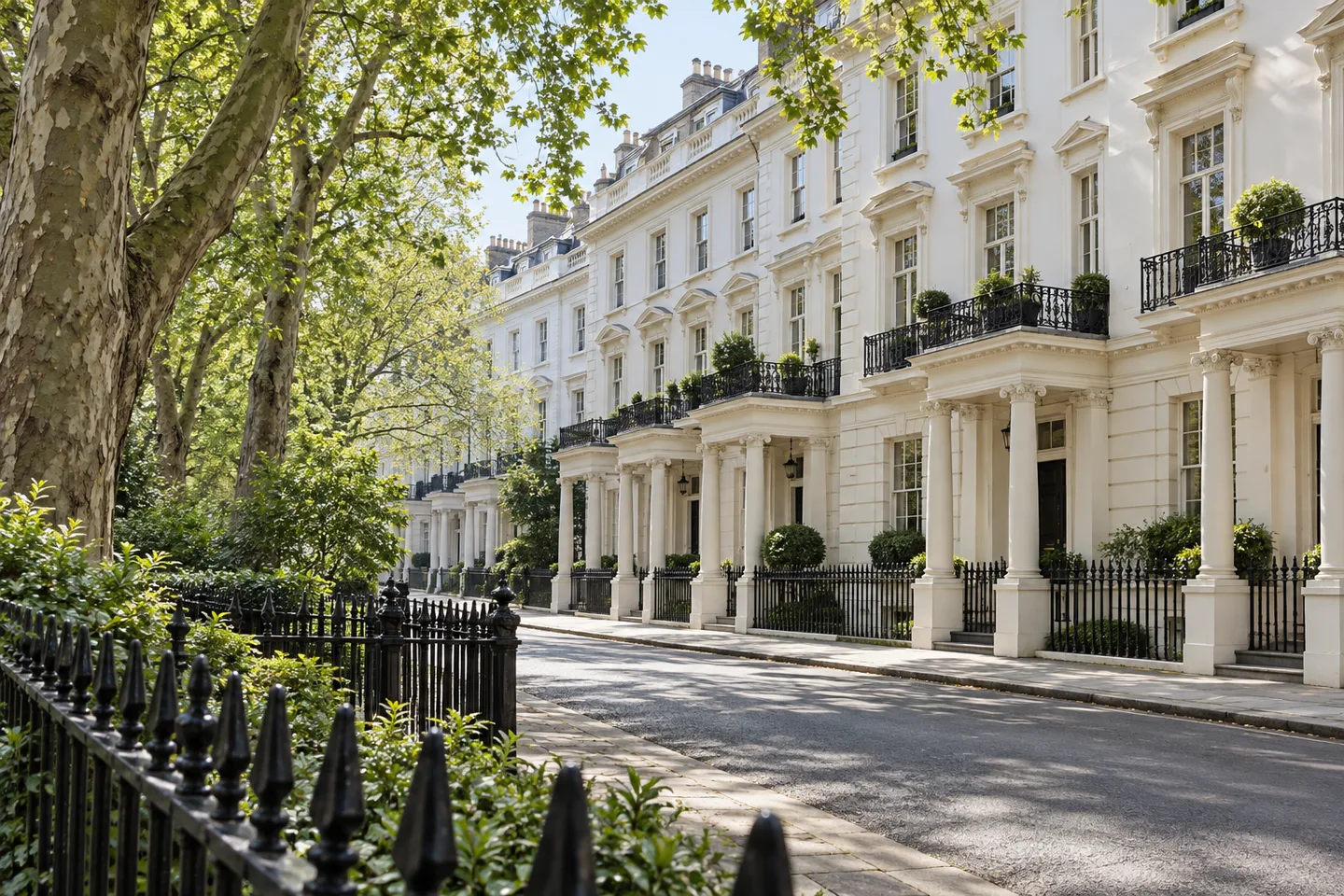 Pale stucco terrace facing a railed garden square shaded by mature plane trees